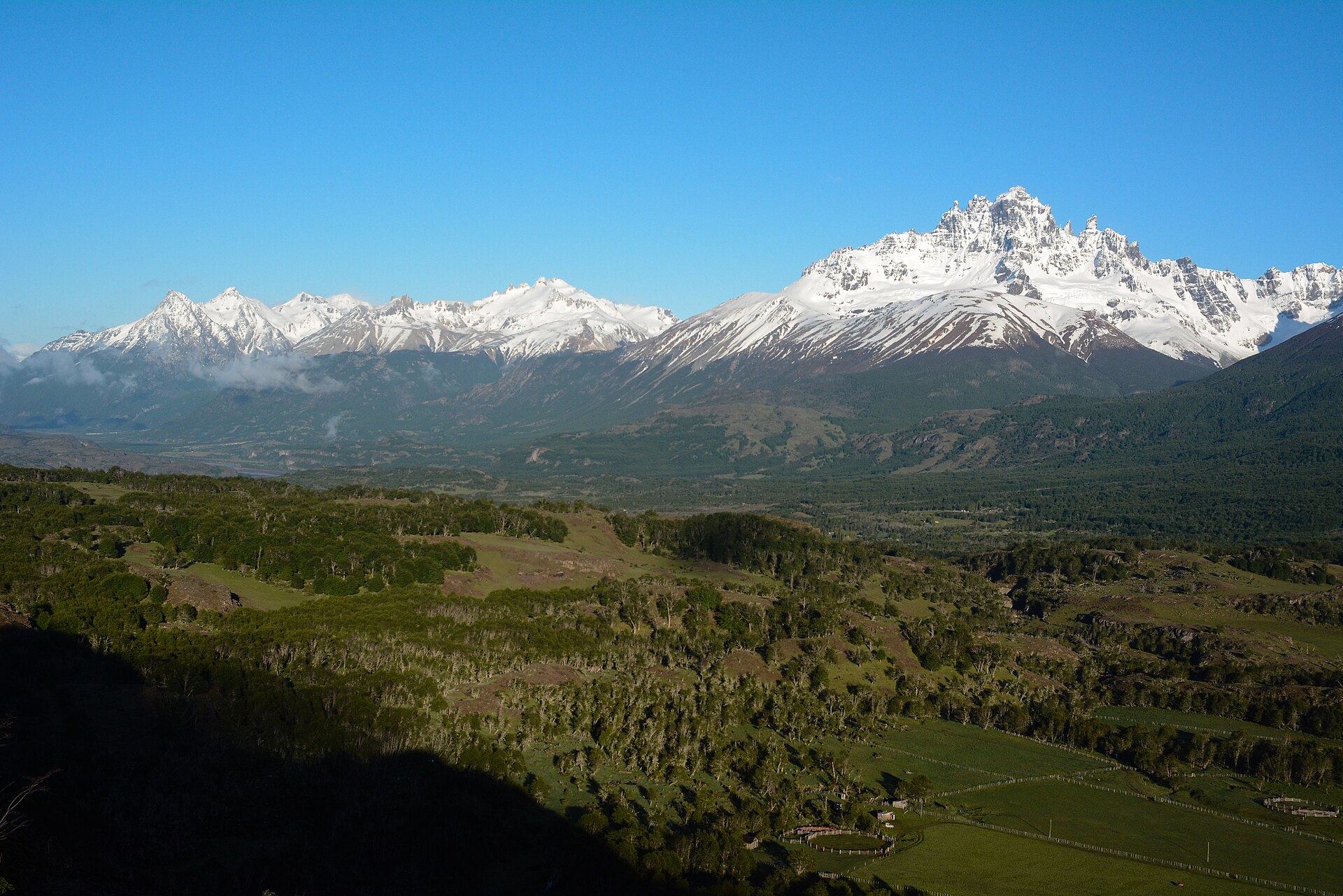 Cerro Castillo rising above forest and fields near Villa Cerro Castillo