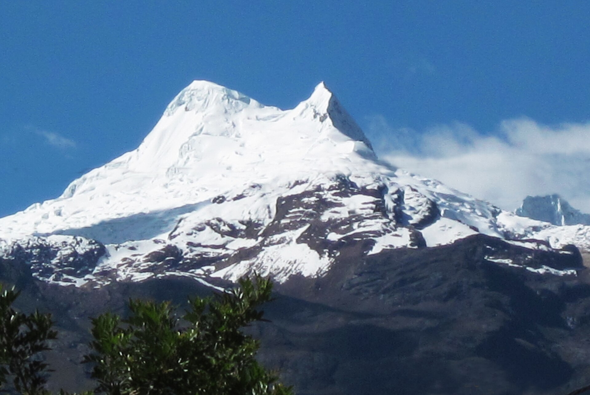 The white summit of Vallunaraju rising above the Cordillera Blanca foothills