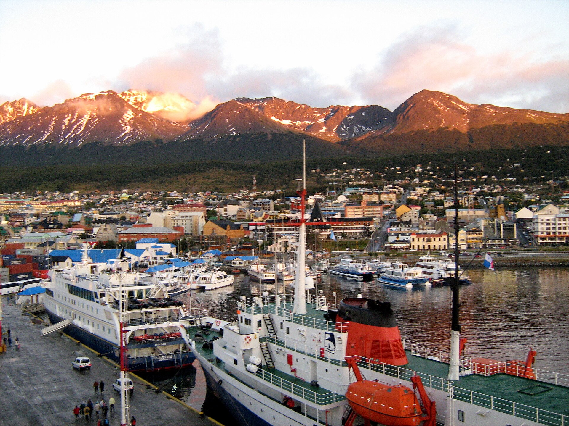 Ships moored in Ushuaia harbour beneath mountains at the Beagle Channel
