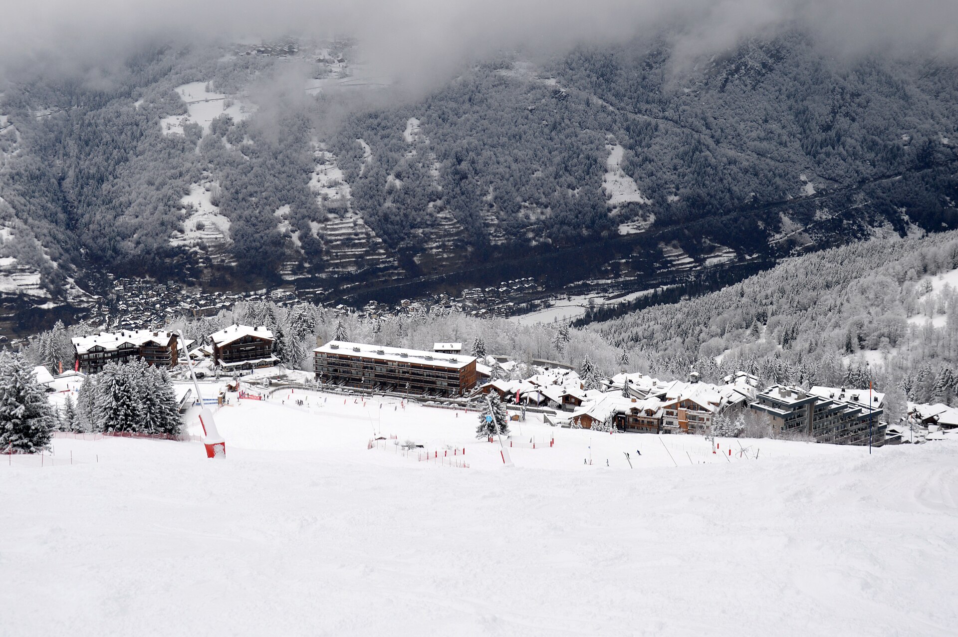 Courchevel Village and its snow front beneath forested Alpine slopes